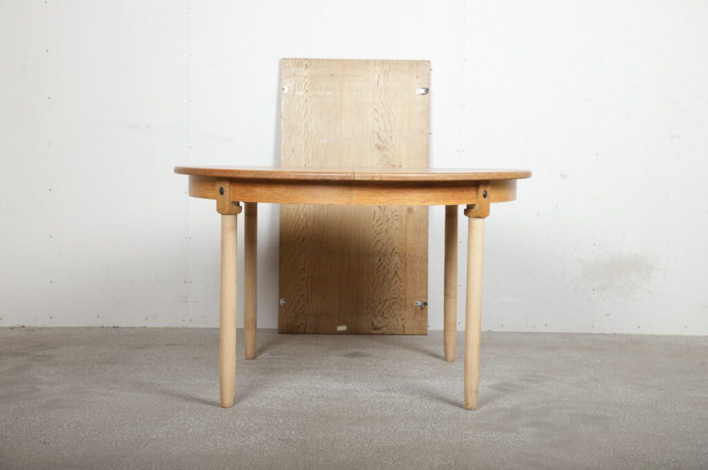 Rundt spisebord i massiv egetræ med én tillægsplade og runde ben (b94)