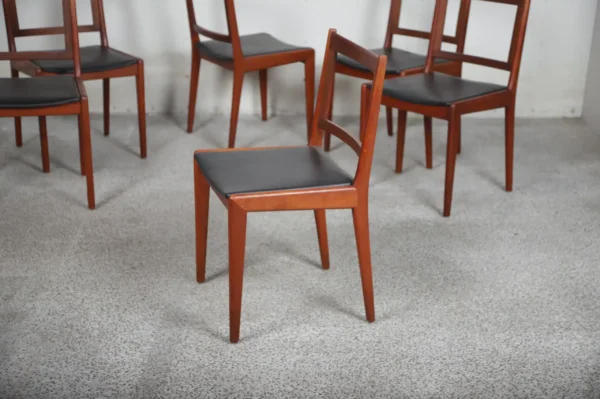 Seks spisestole i massiv teak med polstring i sort læder