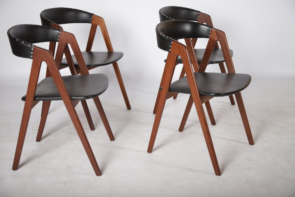 Fire savbuk spisestole med sort sæde- og rygpolstring, teak