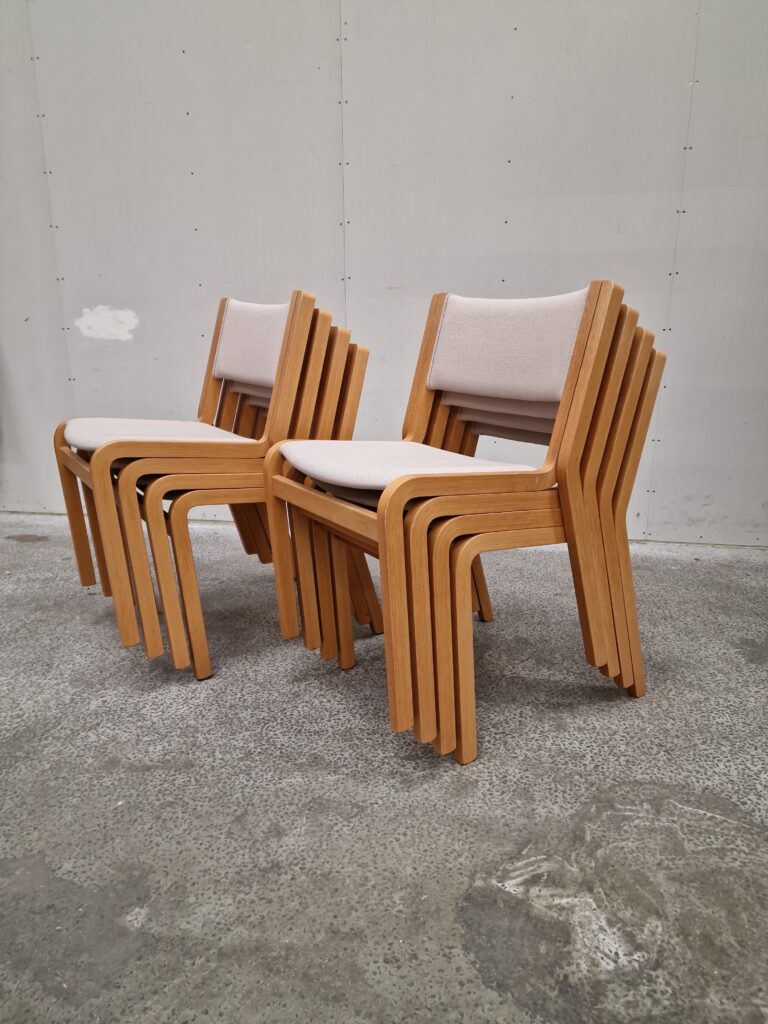Stack of eight mid-century modern wooden chairs.