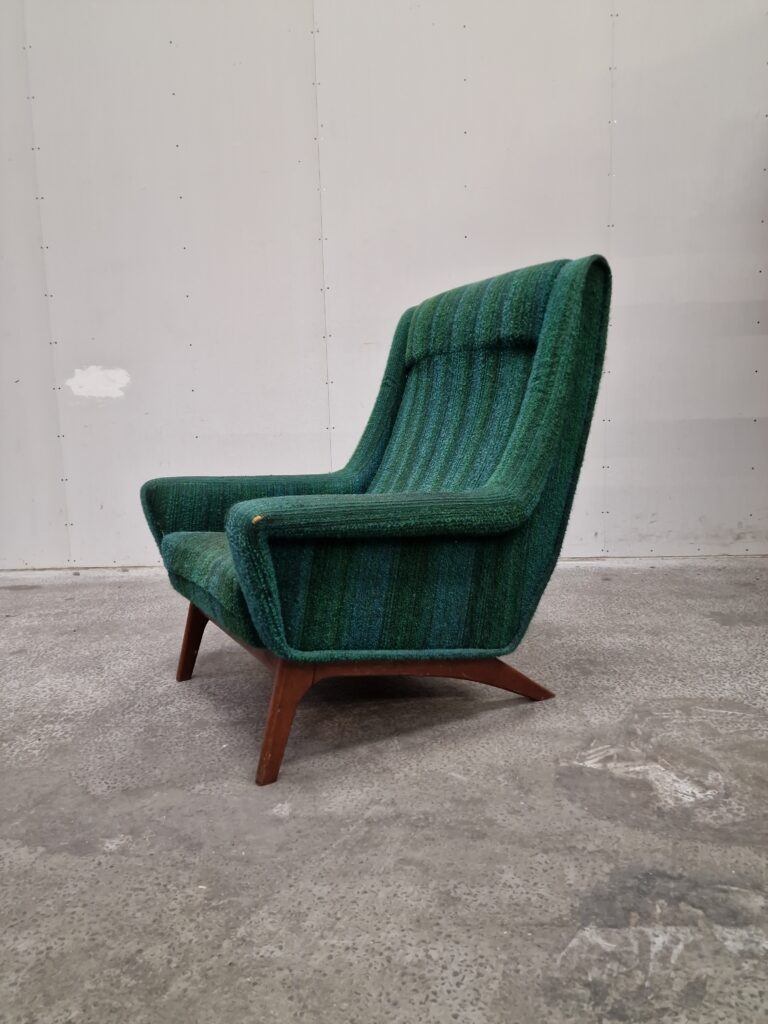 Mid-century modern teal armchair with sculpted back.
