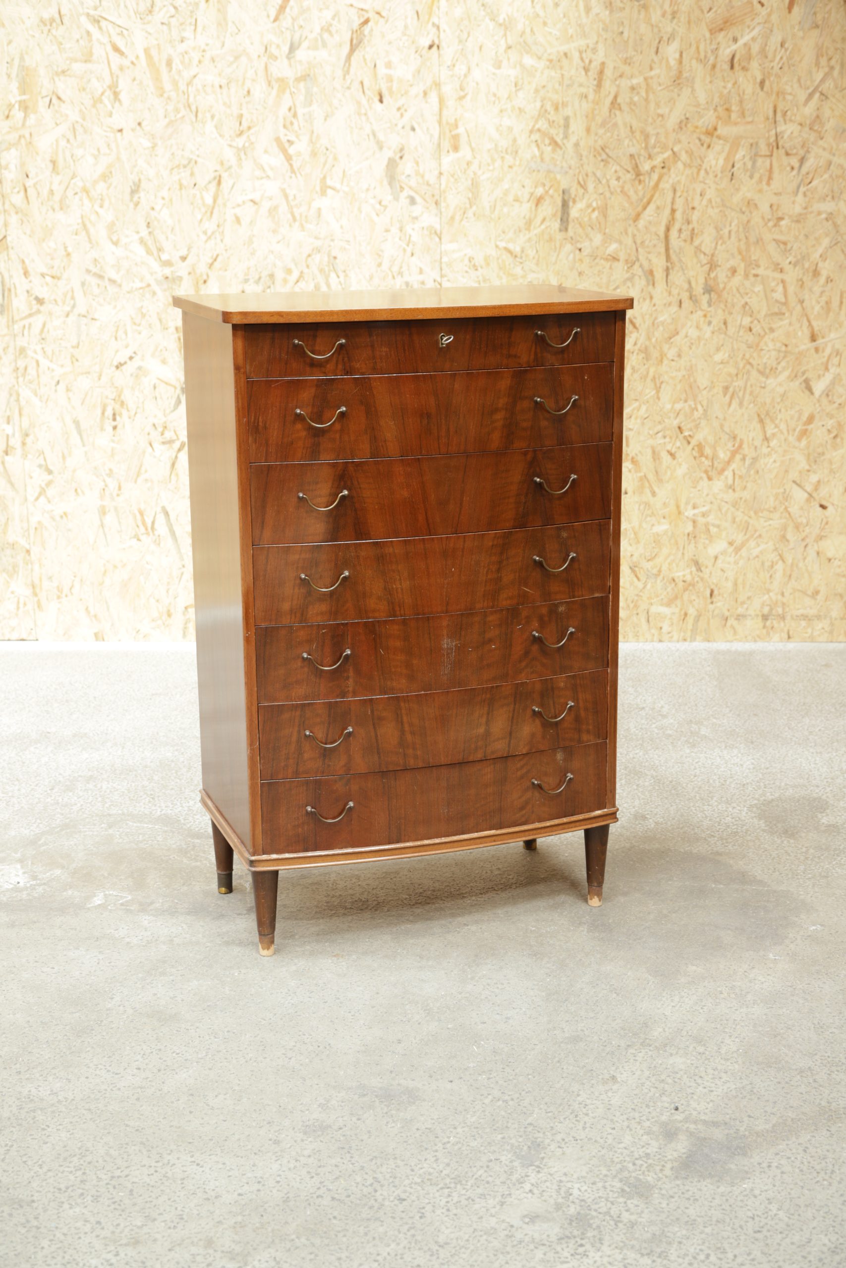 Vintage walnut chest of drawers with seven drawers and brass pulls.