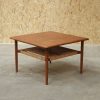 Mid-century modern teak coffee table with woven shelf.