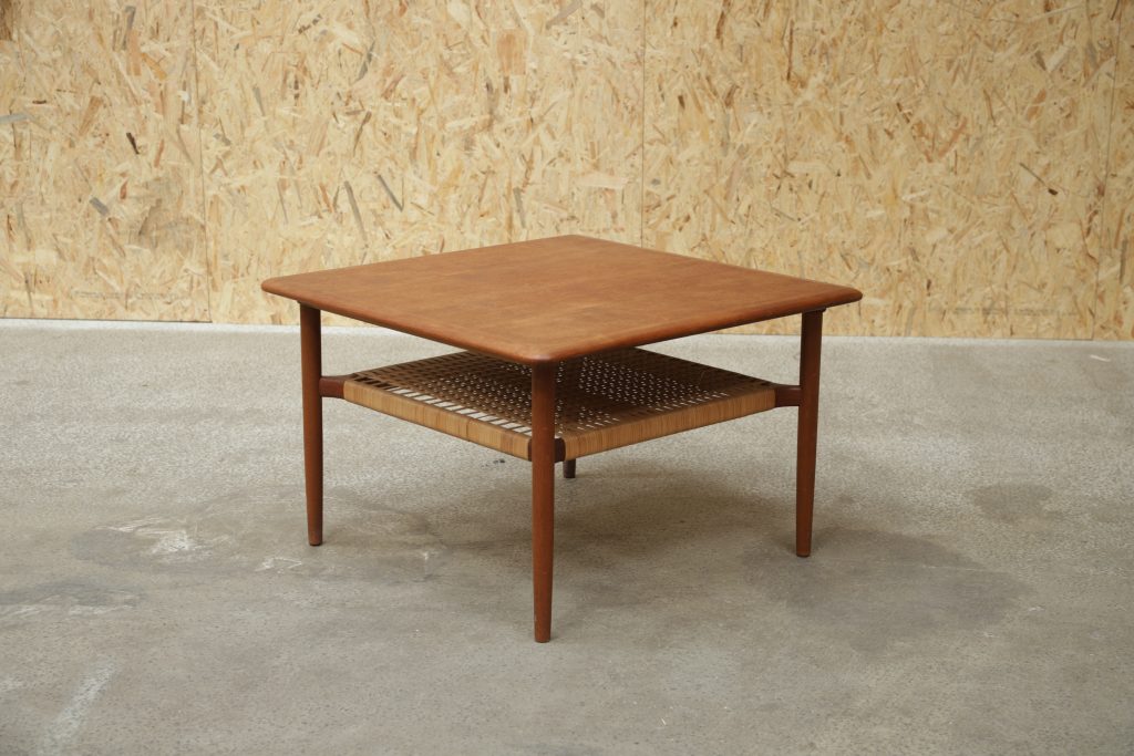 Mid-century modern teak coffee table with woven shelf.