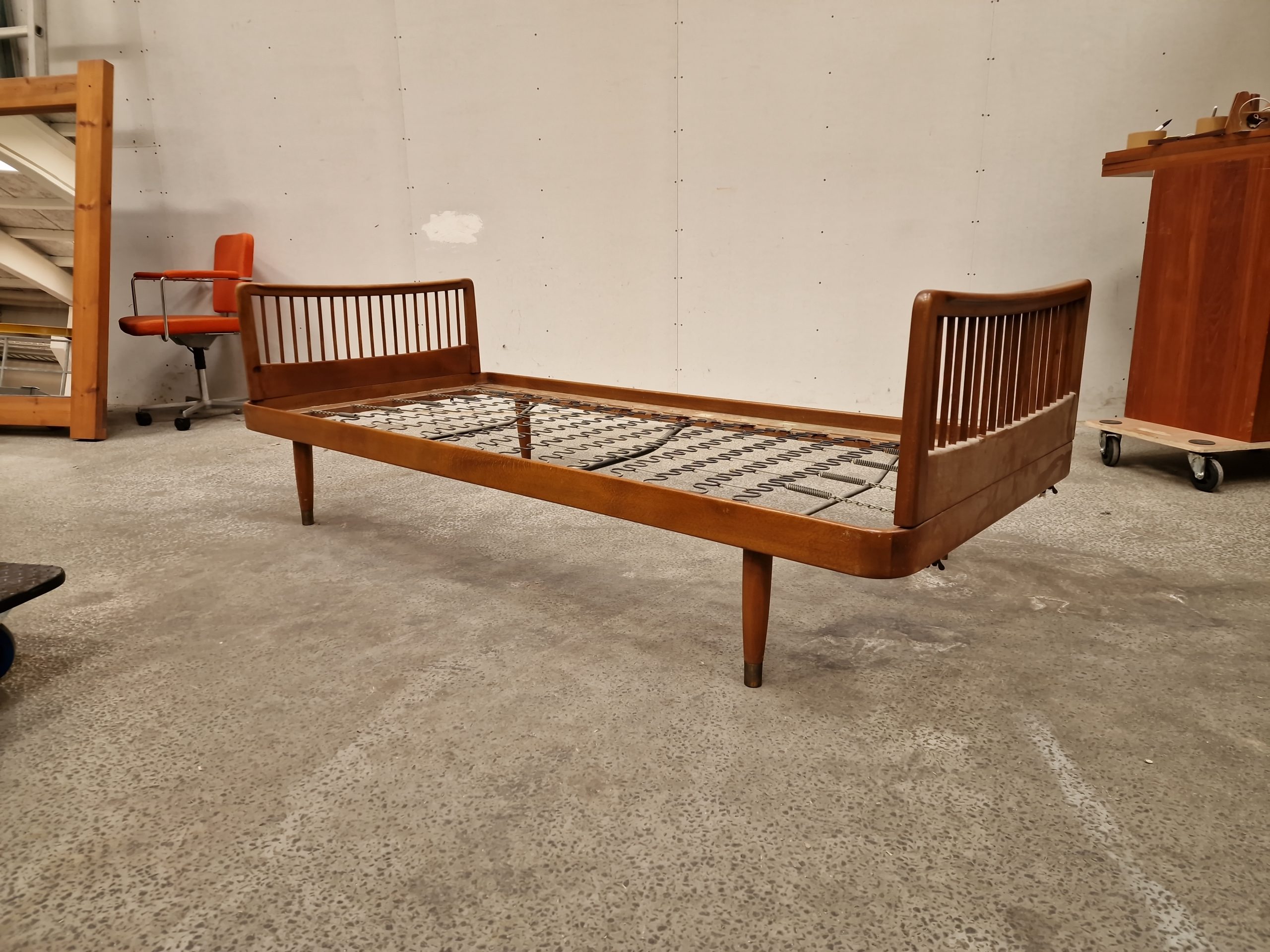 Mid-century modern wooden daybed with slat headboards, stylish furniture.