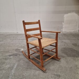 Rustic wooden rocking chair with woven seat.