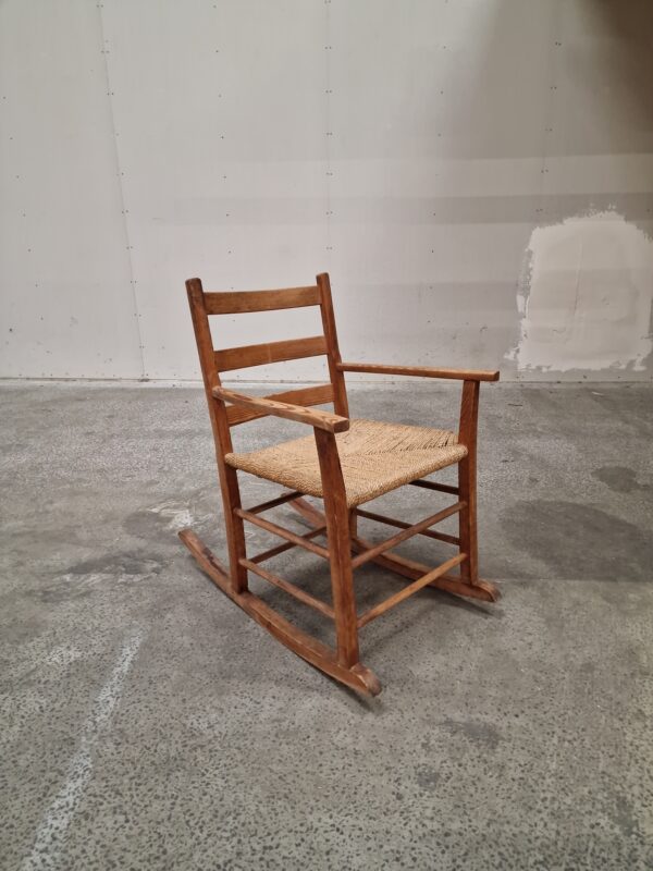 Rustic wooden rocking chair with woven seat.