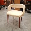 Worn beige armchair with unique cutout back.