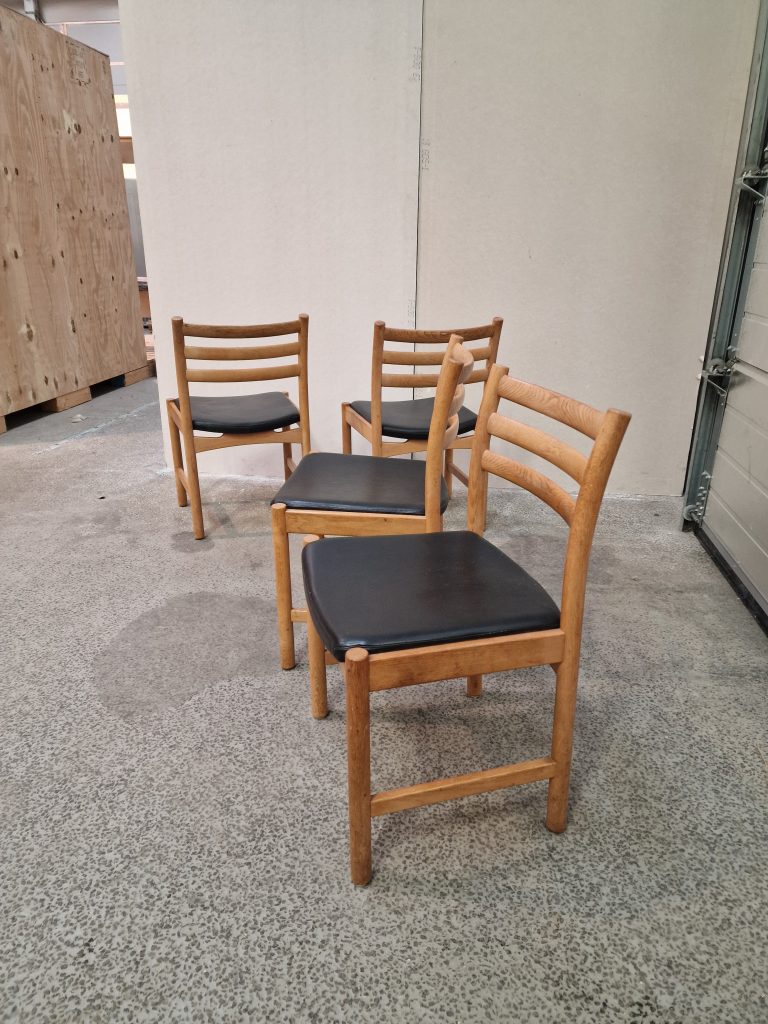 Fire spisestole i massiv egetræ og sort sæde