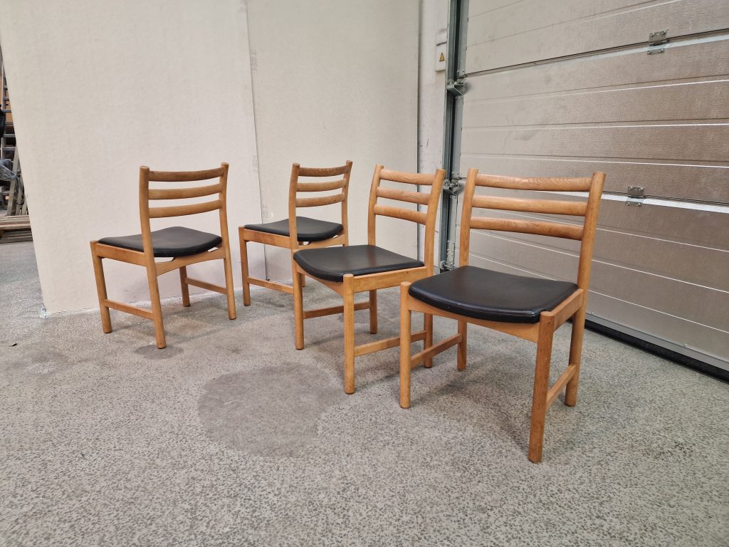 Fire spisestole i massiv egetræ og sort sæde