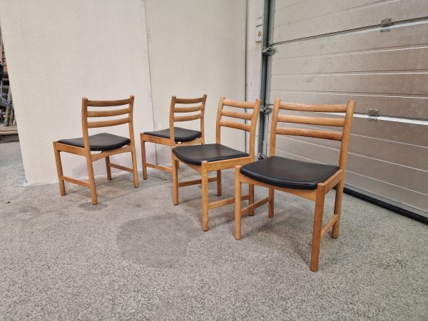 Fire spisestole i massiv egetræ og sort sæde