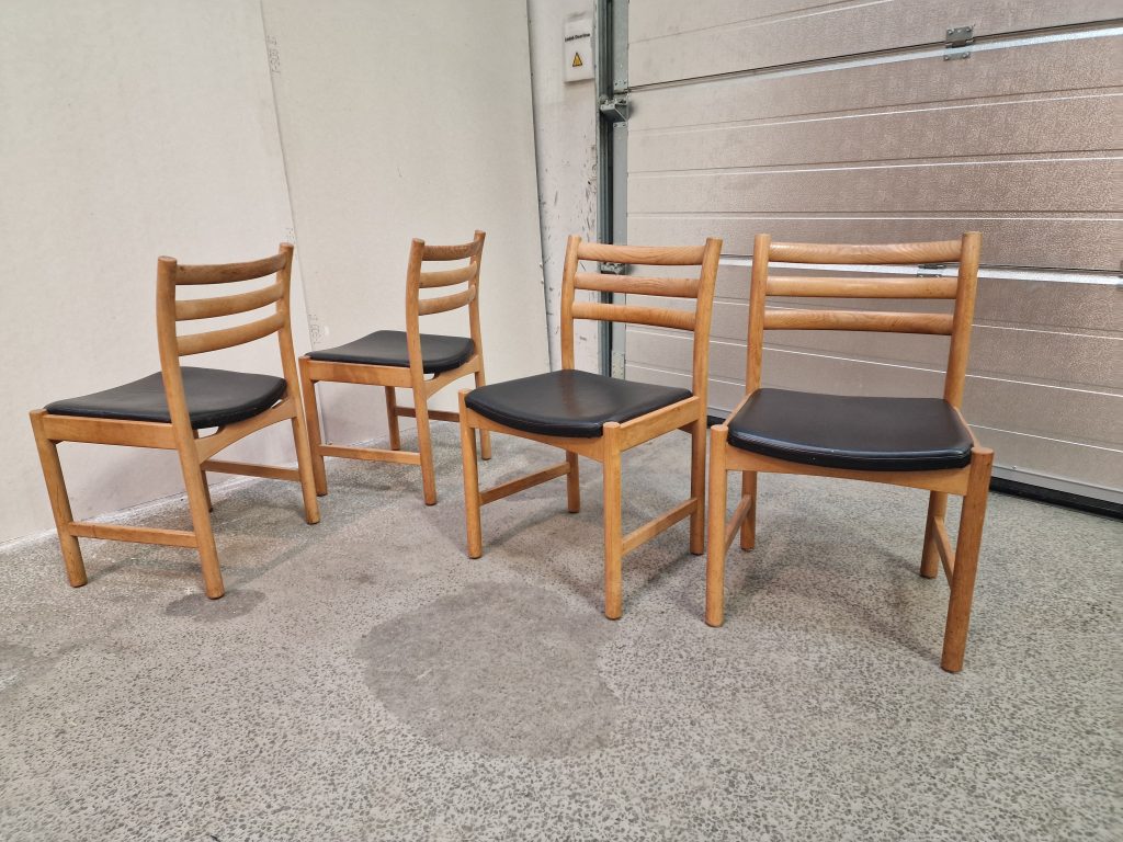 Fire spisestole i massiv egetræ og sort sæde