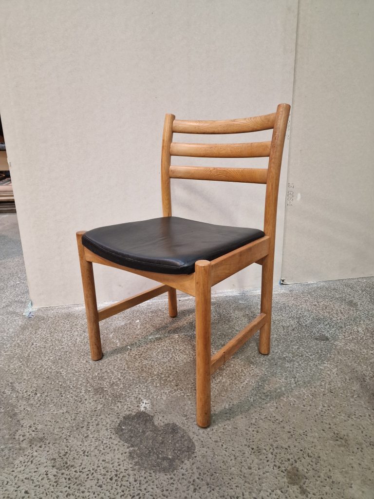 Fire spisestole i massiv egetræ og sort sæde