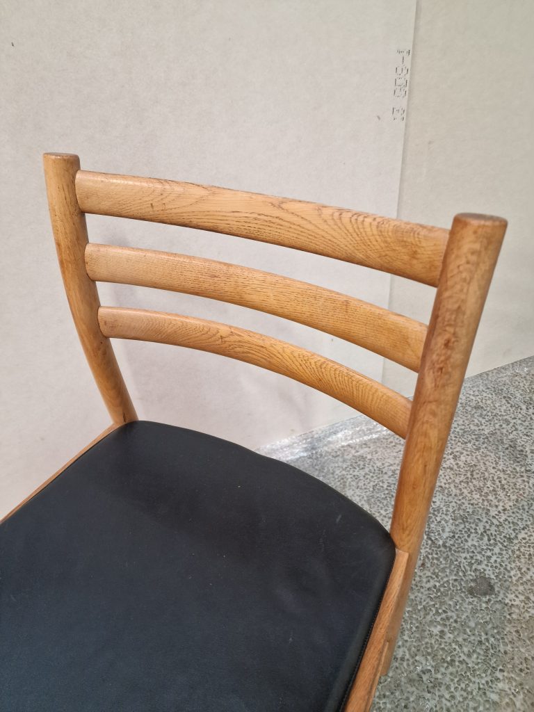 Fire spisestole i massiv egetræ og sort sæde