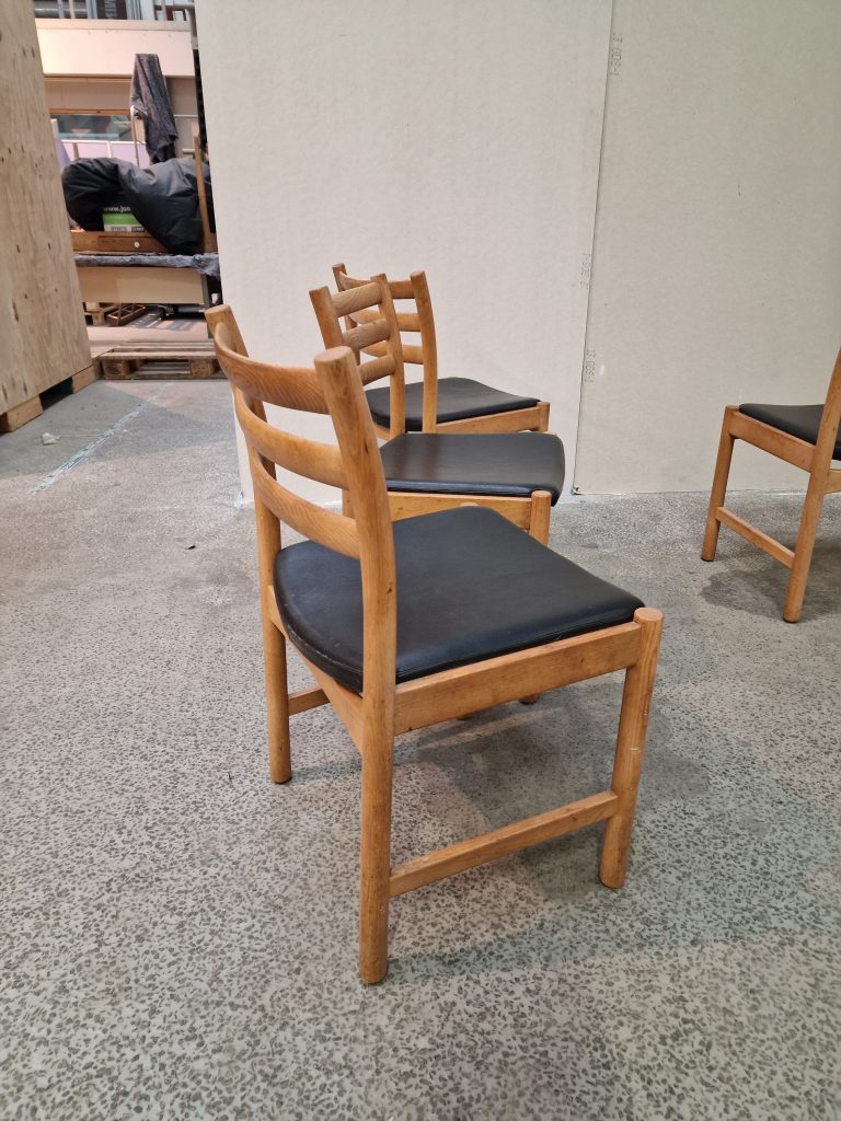 Fire spisestole i massiv egetræ og sort sæde