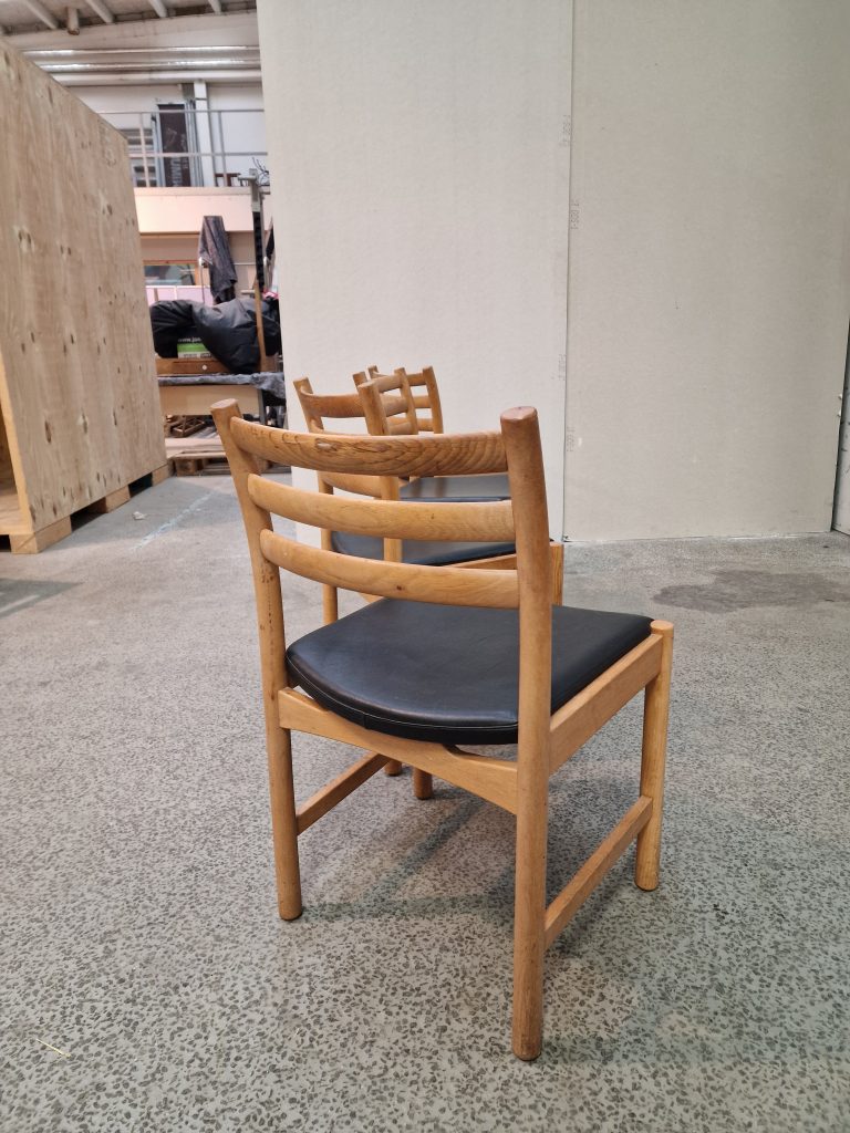 Fire spisestole i massiv egetræ og sort sæde