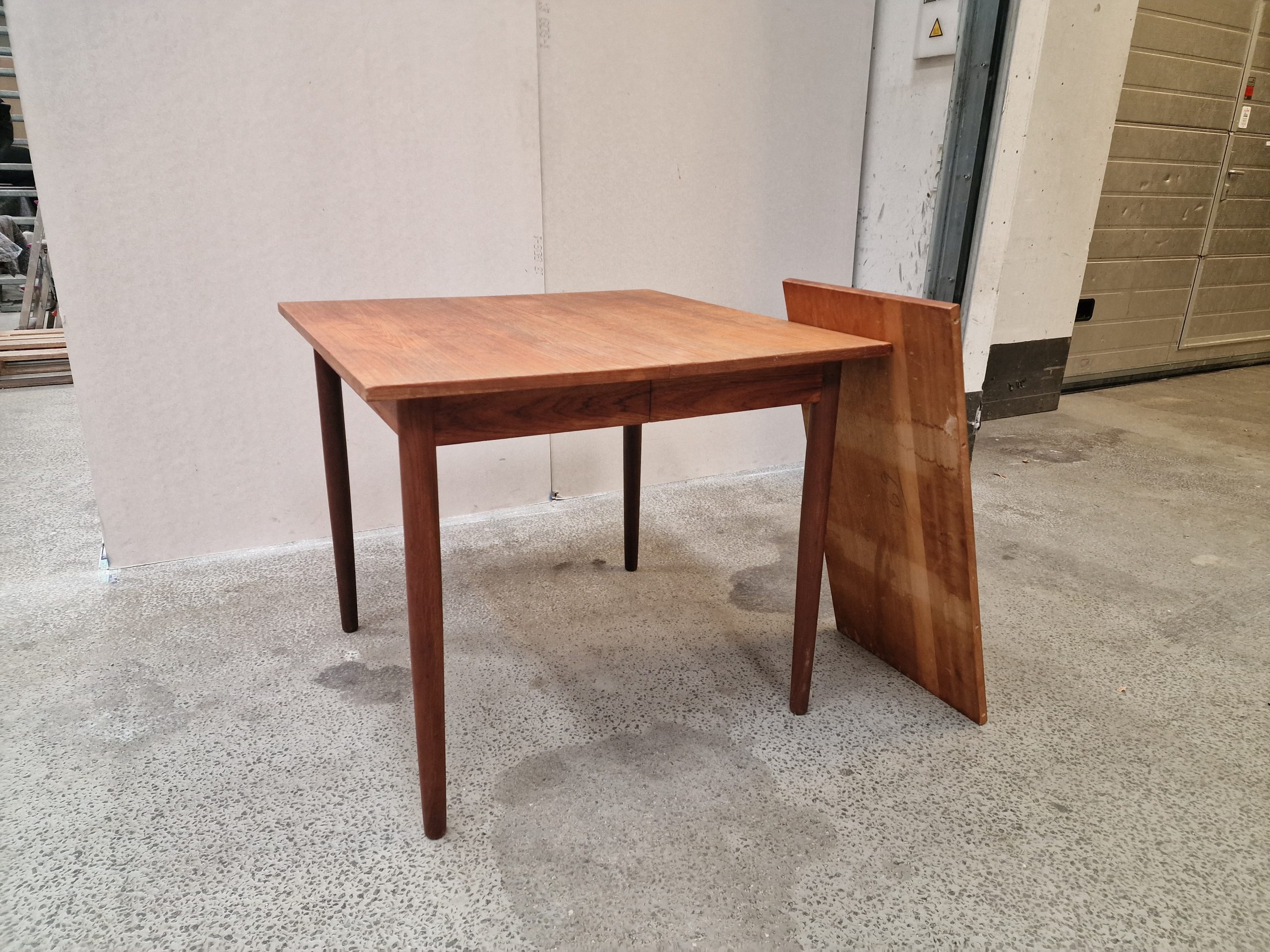 Kvadratisk spisebord i teak med én tillægsplade